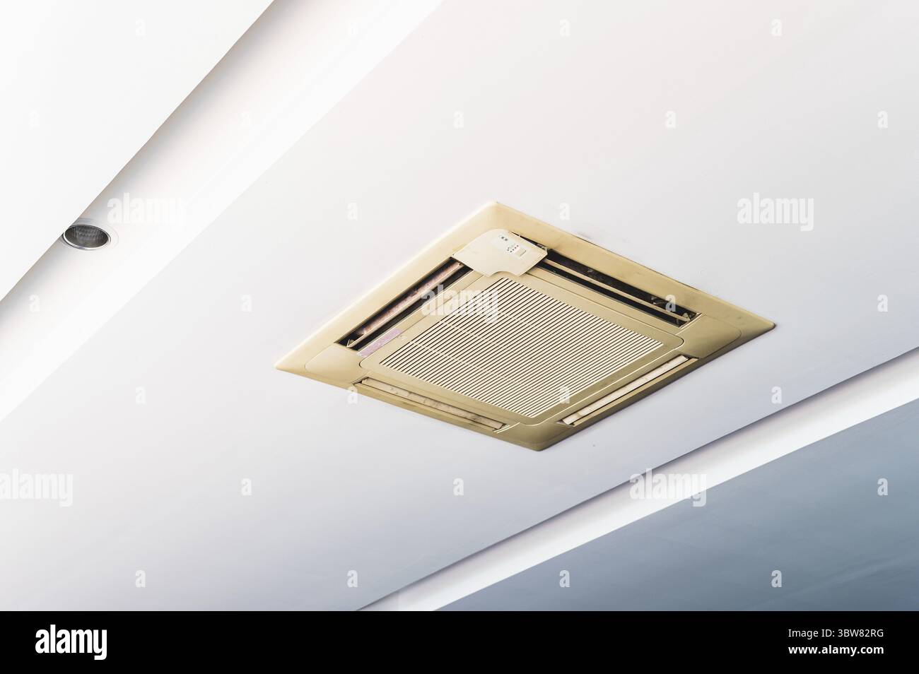 Old cassette type air conditioner on ceiling indoor. Electronics and purifier concept Stock Photo