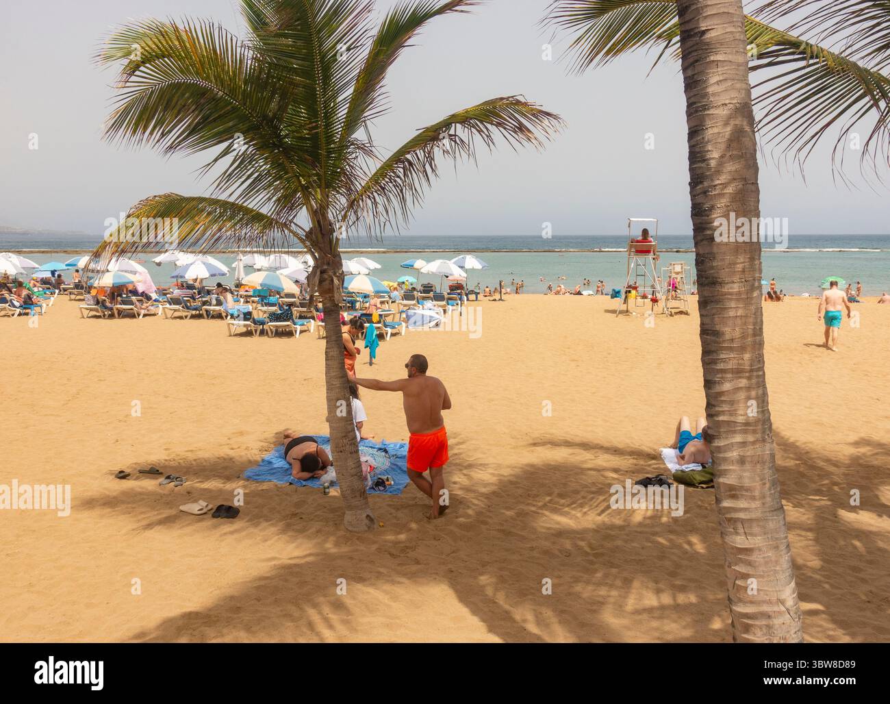 Las Palmas, Gran Canaria, Canary Islands, Spain.16th July, 2025. Tourists, many British, swelter on the city beach in Las Palmas as the midday temperature registers 38.7 degrees Celcius in the south of Gran Canaria. A cocktail of high temperatures and winds blowing in from the Sahara has activated an orange health and forest fire risk alert throughout the Canary Islands. Credit: Alan Dawson/Alamy Live News Stock Photo