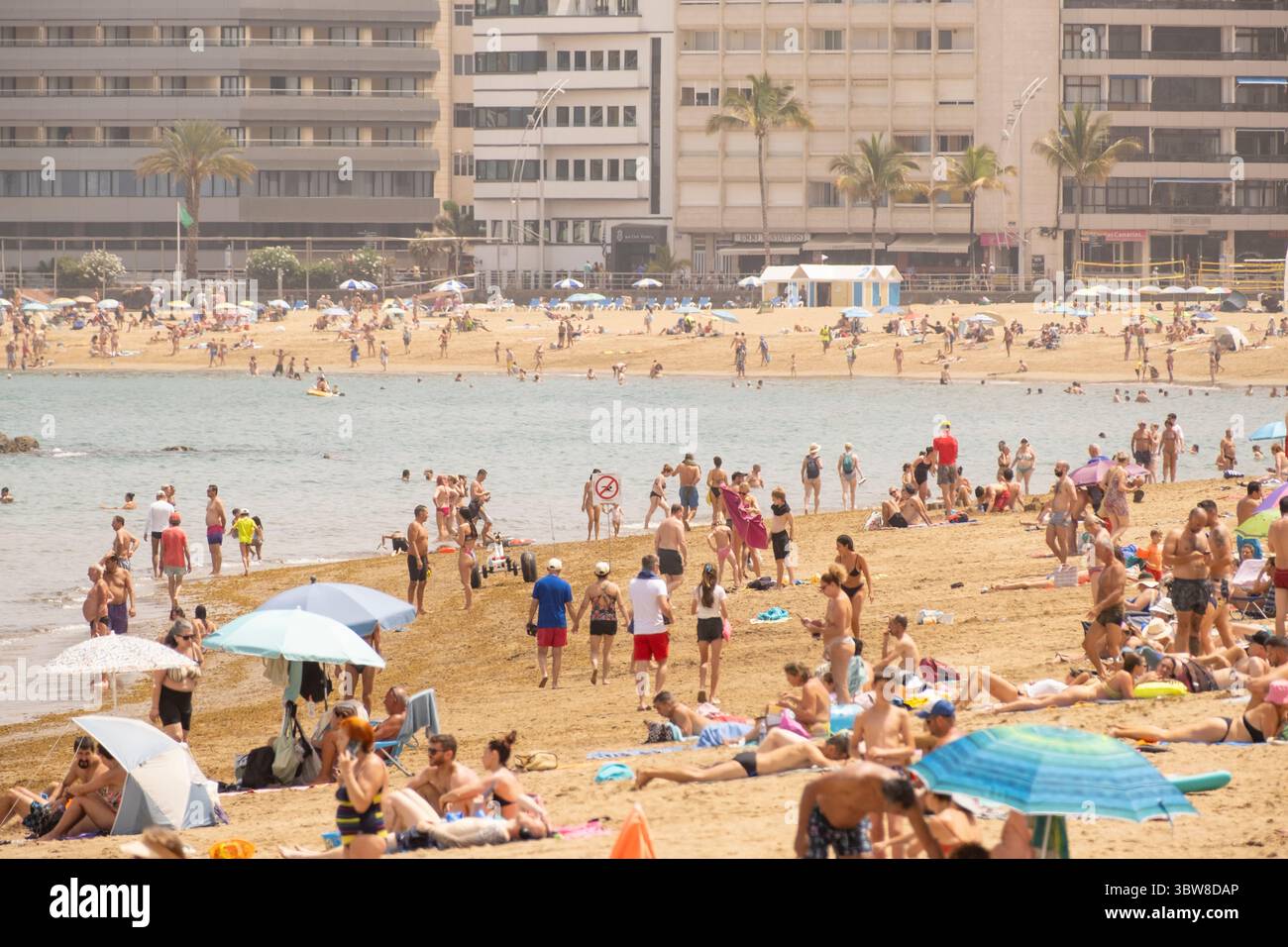 Las Palmas, Gran Canaria, Canary Islands, Spain.16th July, 2025. Tourists, many British, swelter on the city beach in Las Palmas as the midday temperature registers 38.7 degrees Celcius in the south of Gran Canaria. A cocktail of high temperatures and winds blowing in from the Sahara has activated an orange health and forest fire risk alert throughout the Canary Islands. Credit: Alan Dawson/Alamy Live News Stock Photo