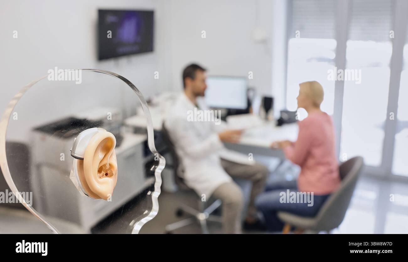 Display with silicone ear and hearing aid behind the ear shows concept ...