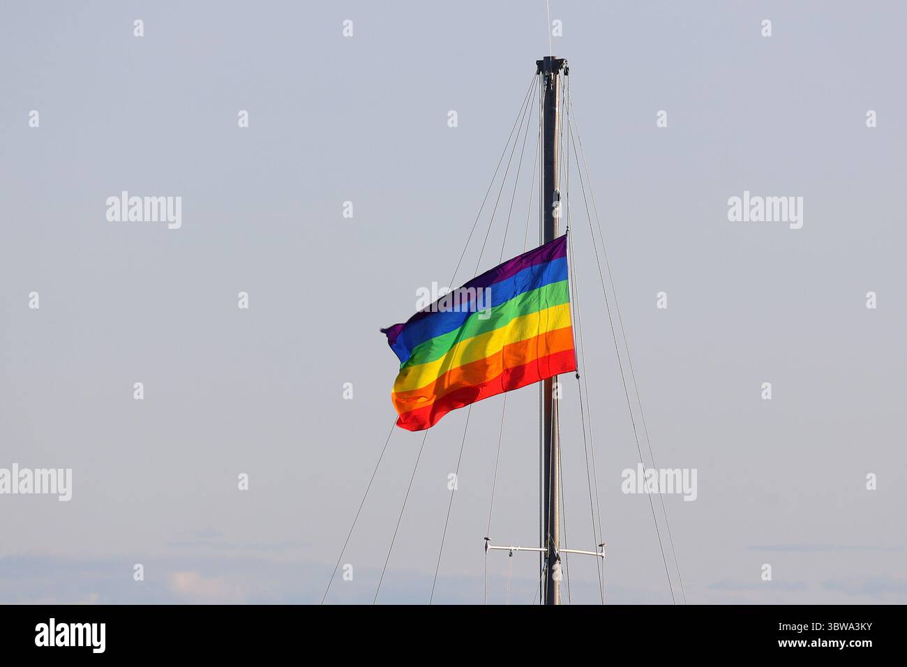 Rainbow pride flag hanging on boat mast Stock Photo