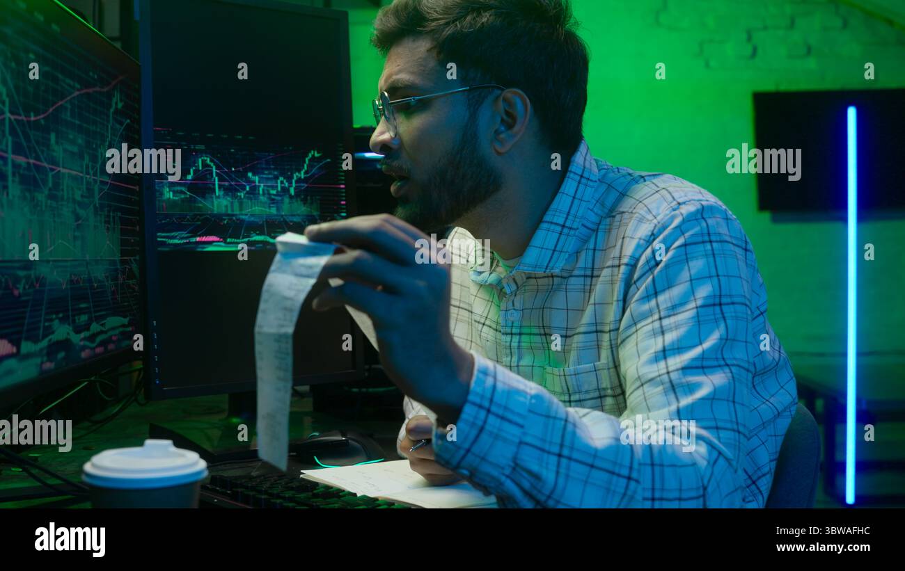 Arabian Indian man male guy programmer examining writing binary code coder freelancer engineer worker IT specialist monitor analyzing computer Stock Photo