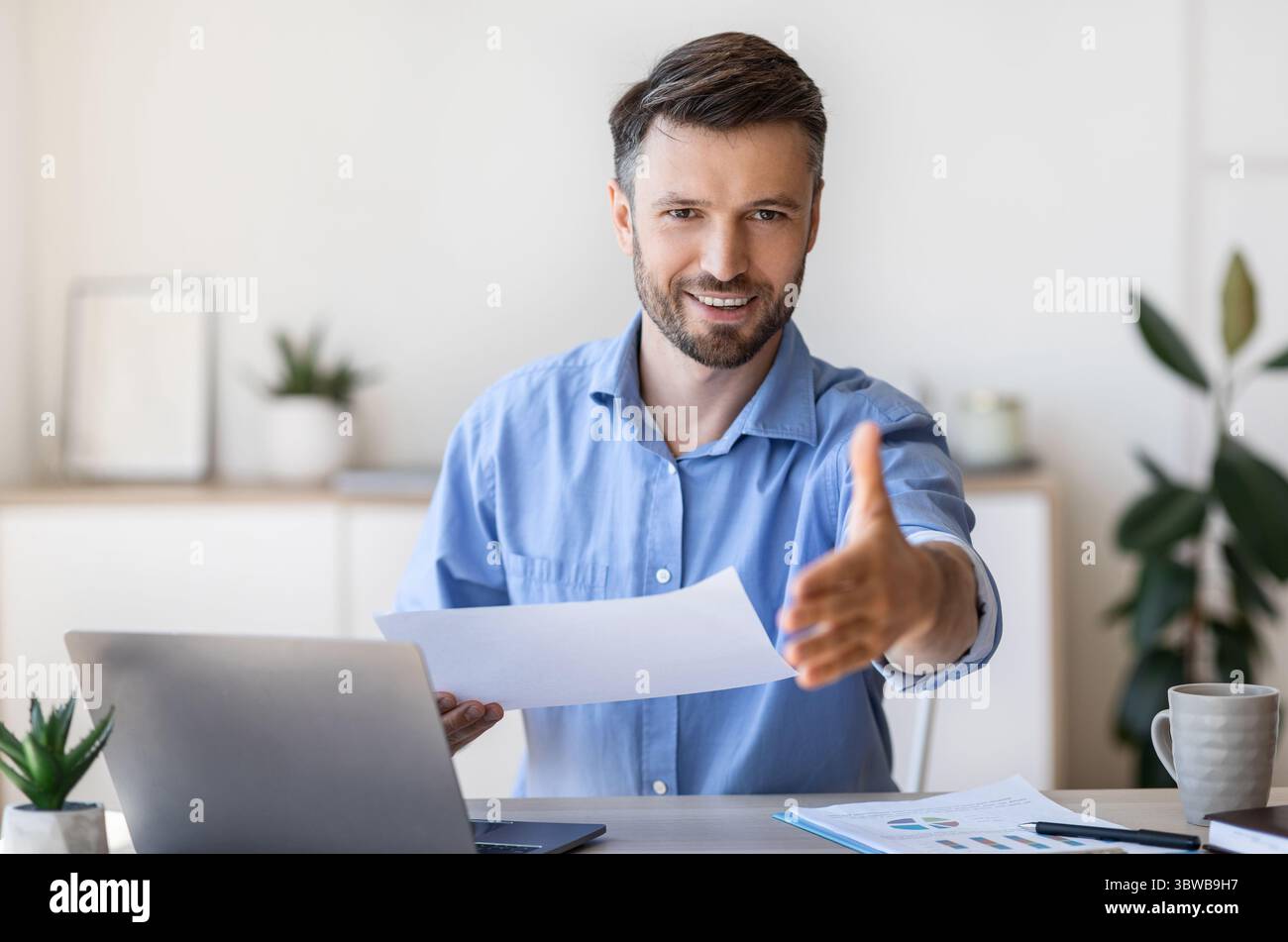 Job Interview. Friendly male HR manager extending hand for handshake at camera Stock Photo