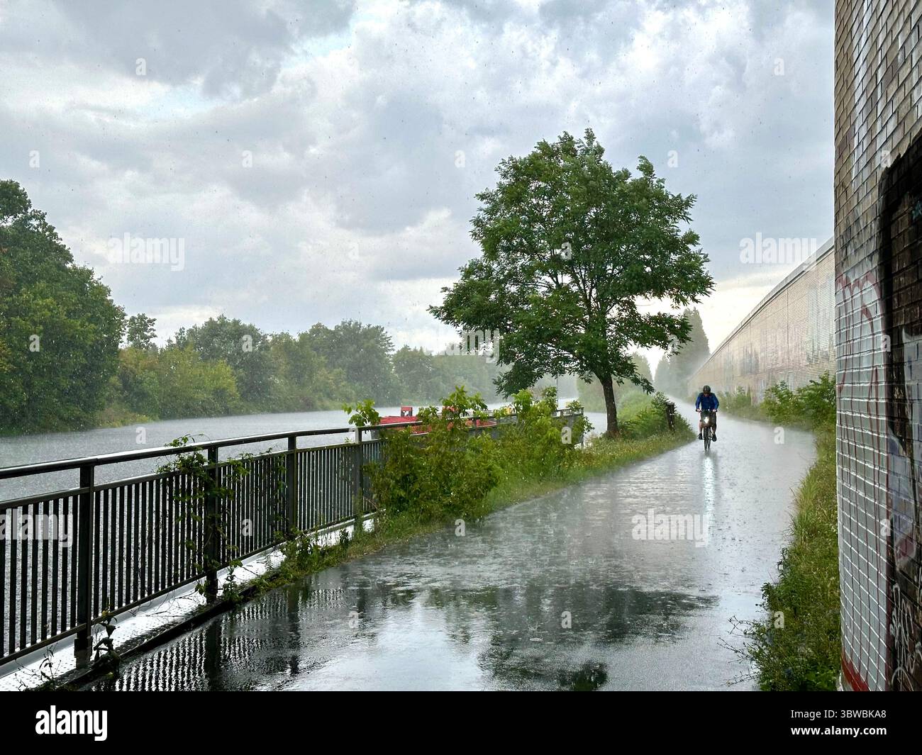 View from a street under a bridge next to the Teltow Kanal in Berlin into pouring rain - Smartphone Captured Stock Image