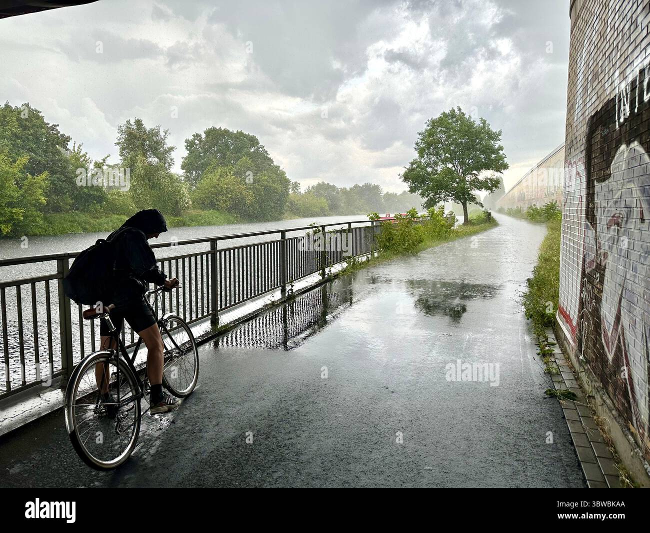 View from a street under a bridge next to the Teltow Kanal in Berlin into pouring rain - Smartphone Captured Stock Image