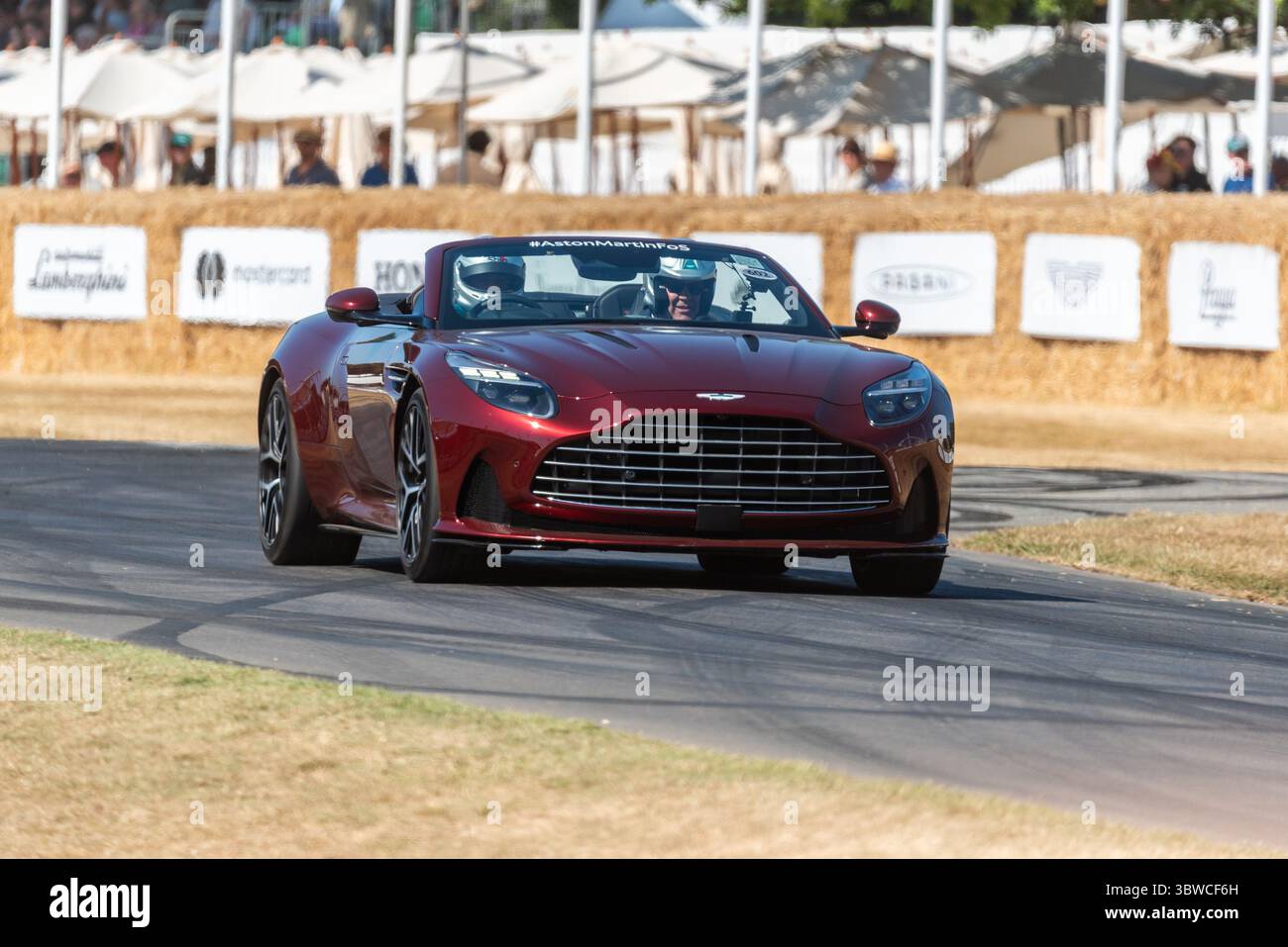 Aston Martin DB12 Volante grand touring car driving up the hillclimb ...