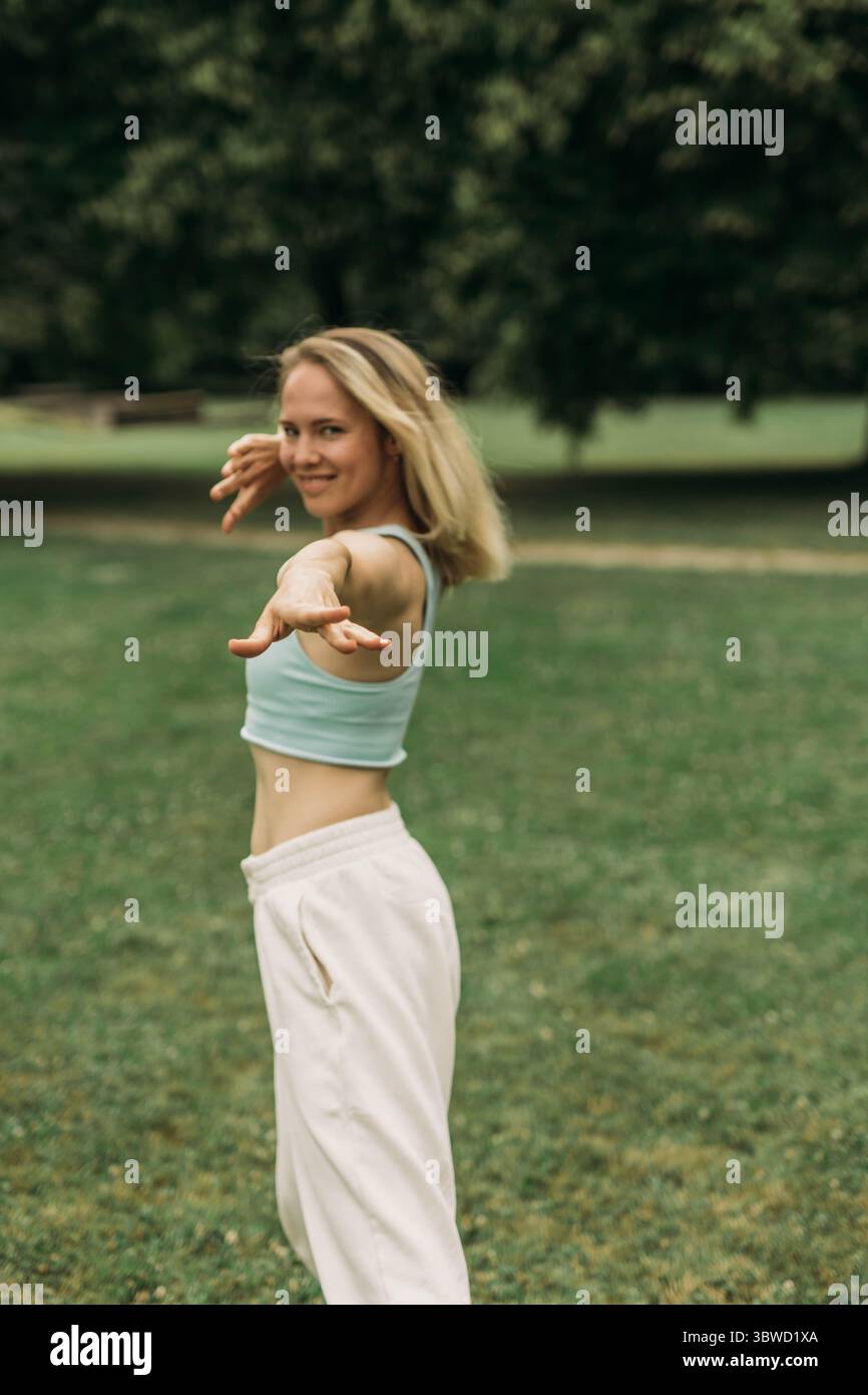 young woman athlete in sportswear practices yoga, enjoys training and breathing exercises,sport and fitness outdoor. High quality photo Stock Photo