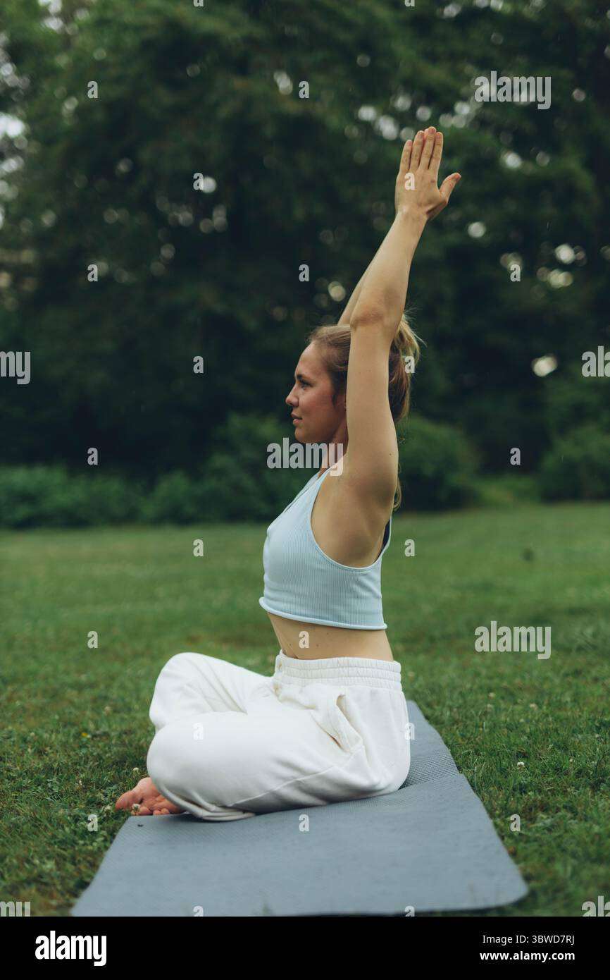 young woman athlete in sportswear practices yoga, enjoys training and breathing exercises,sport and fitness outdoor. High quality photo Stock Photo