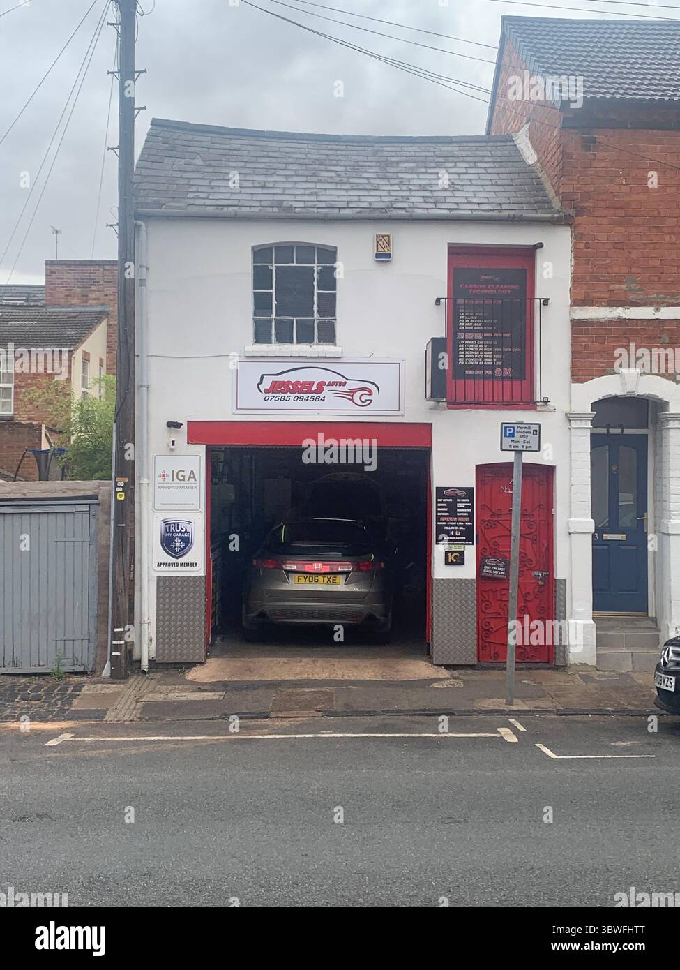 Garage old style type Northampton England British English front entrance car in inside being repaired business local place street sign signs no - Smartphone Captured Stock Image