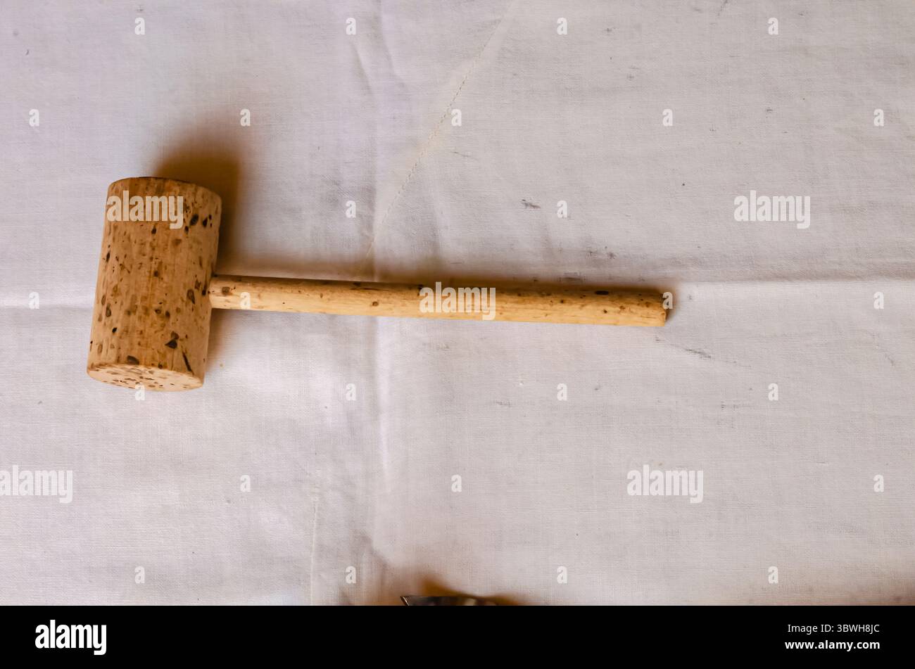 A Meat Mallet On White Fabric Stock Photo
