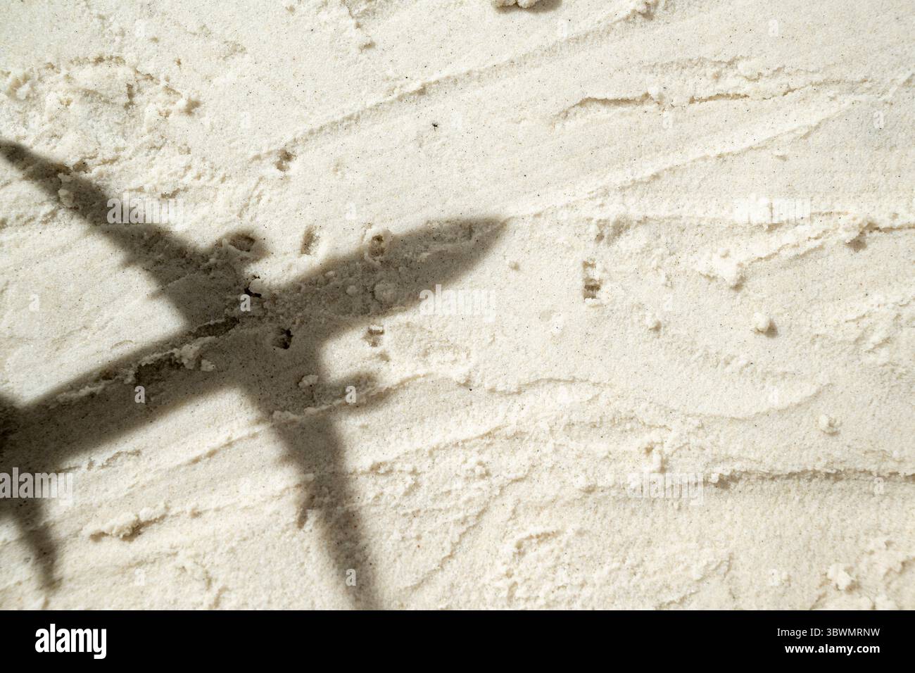 Shadow of an airplane flies over a beautiful sandy beach. Natural ...