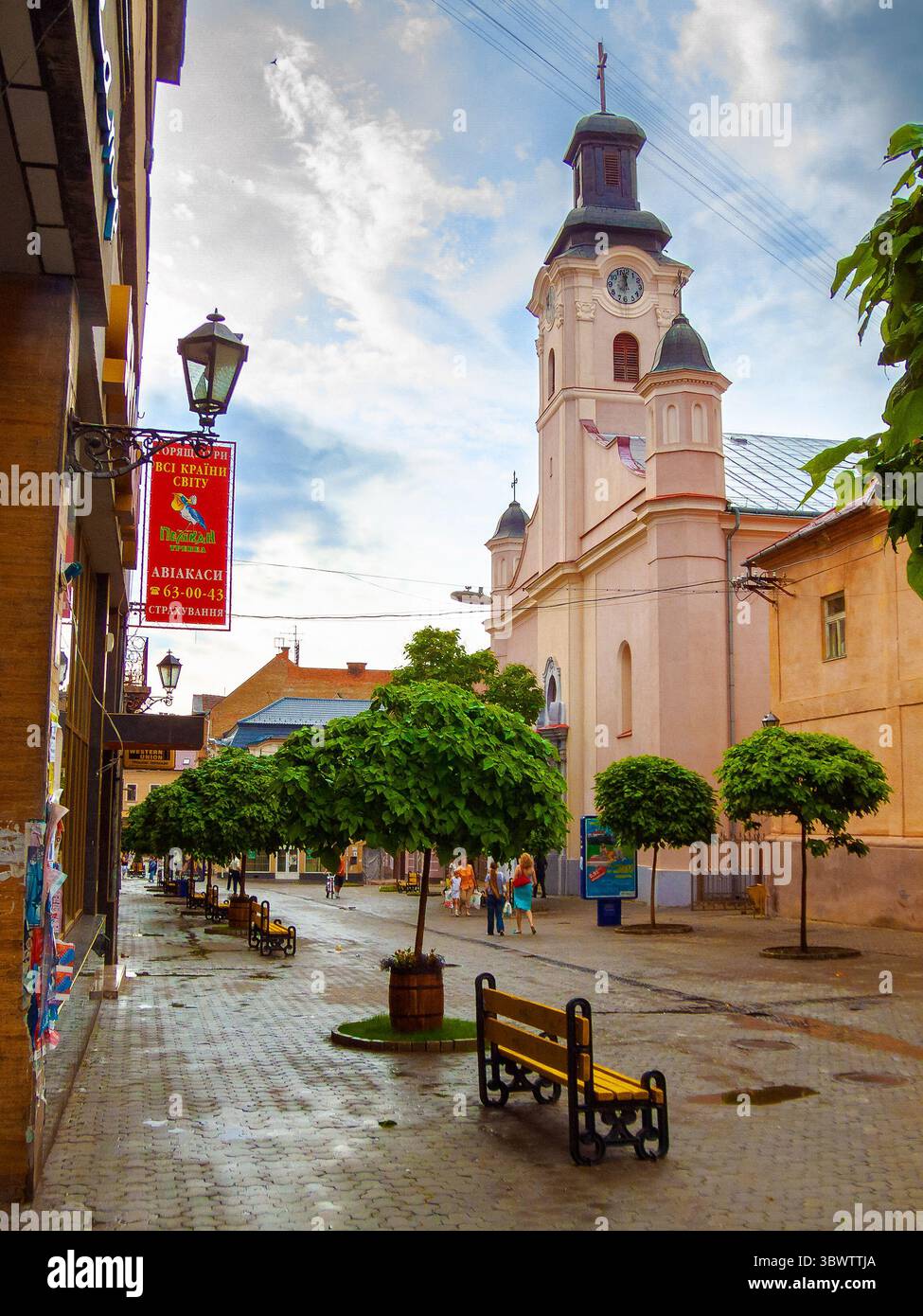 uzhhorod, ukraine - 01 jul, 2007: city after the rain with wet street. beautiful architecture of the historic center. water on the sidewalk. urban lan Stock Photo