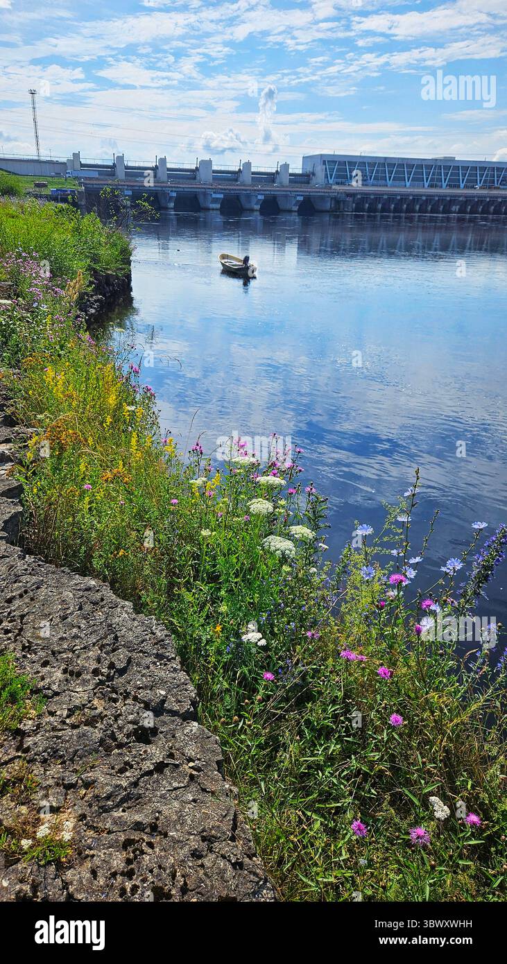 Boat on River Near Hydroelectric Dam.Riga HES.Latvia.17.07.2025 - Smartphone Captured Stock Image