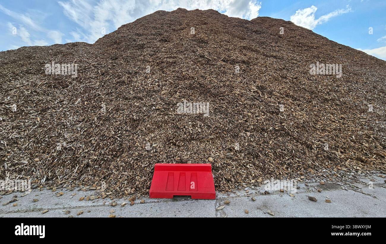 Massive Pile of Wood Chips with Red Barrier and Blue Sky - Smartphone Captured Stock Image