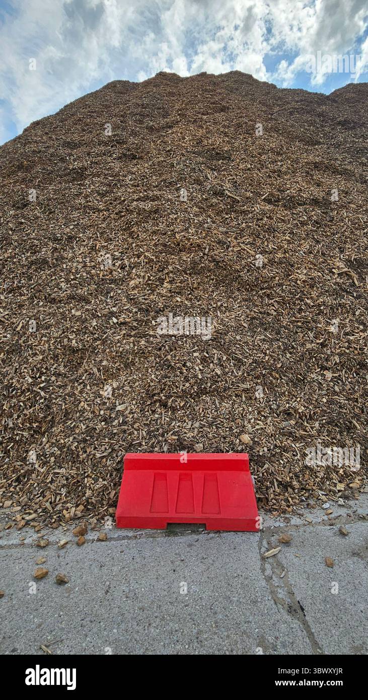 Massive Pile of Wood Chips with Red Barrier and Blue Sky - Smartphone Captured Stock Image