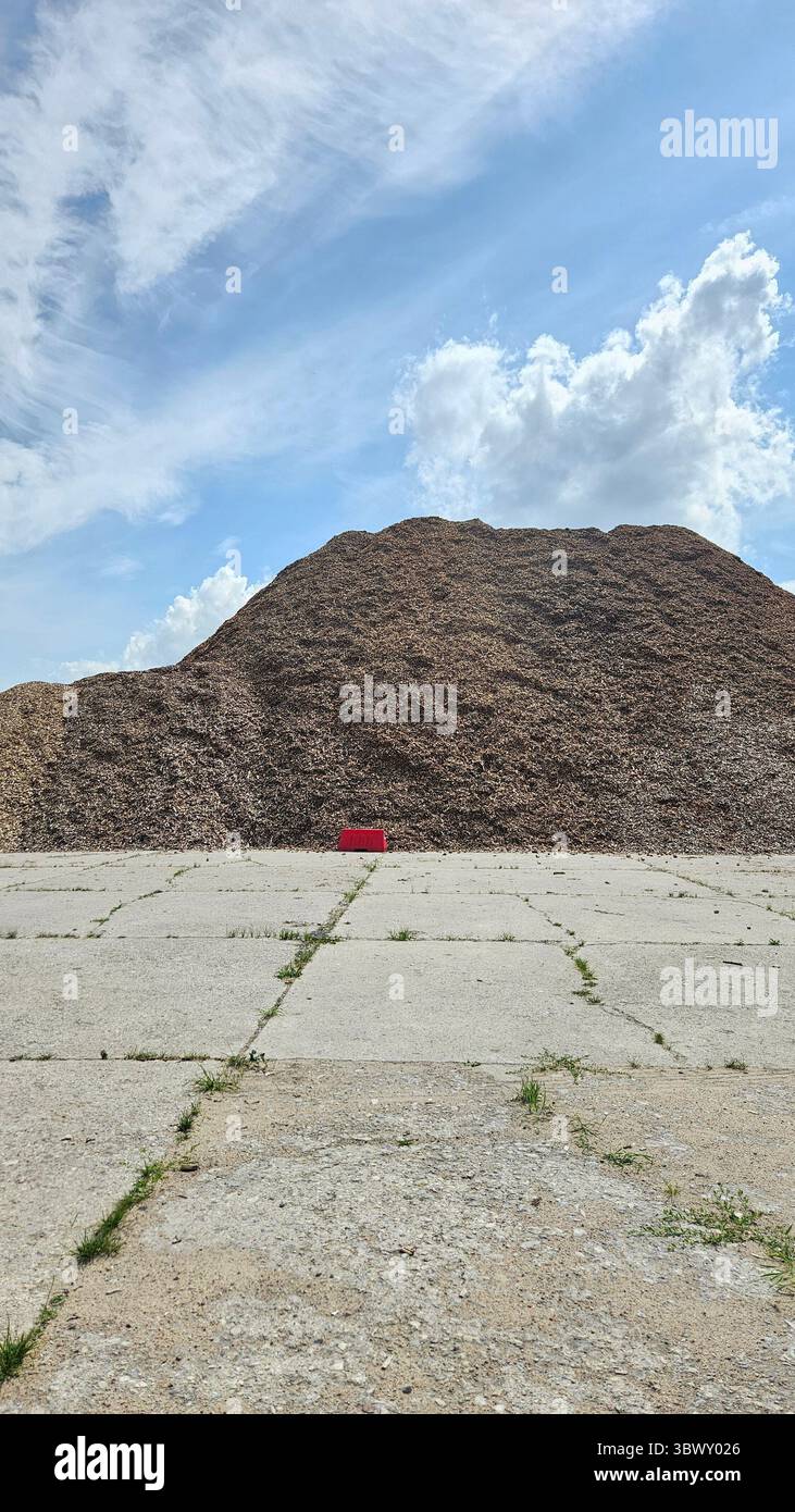 Massive Pile of Wood Chips with Red Barrier and Blue Sky - Smartphone Captured Stock Image