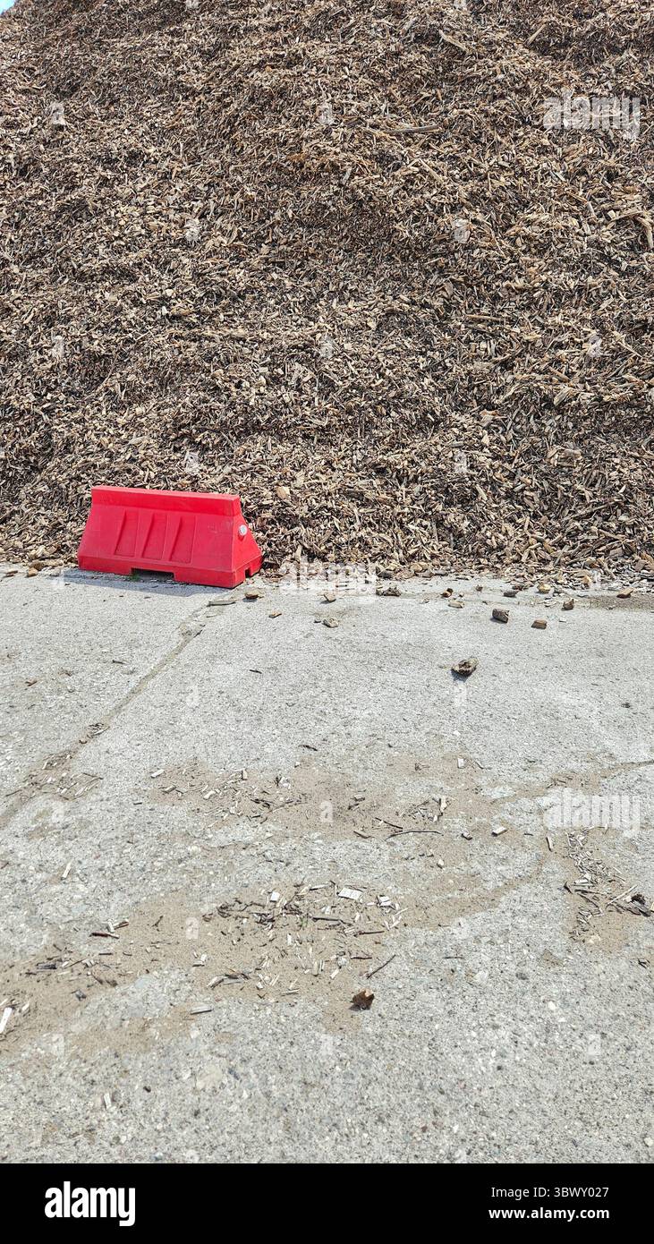 Massive Pile of Wood Chips with Red Barrier and Blue Sky - Smartphone Captured Stock Image
