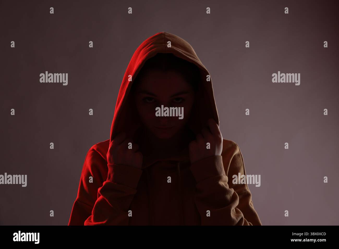 Anonymity. Woman hiding her face on dark background Stock Photo - Alamy