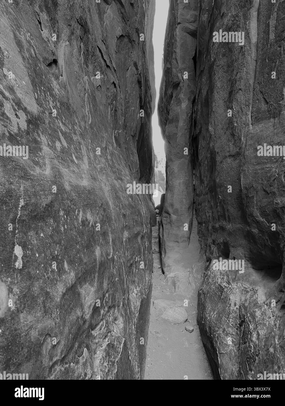 A black and white image of a  slot canyon, made of red sandstone, on the Fiery Furnace Trail in Arches National Park, Moab, Utah, USA - Smartphone Captured Stock Image