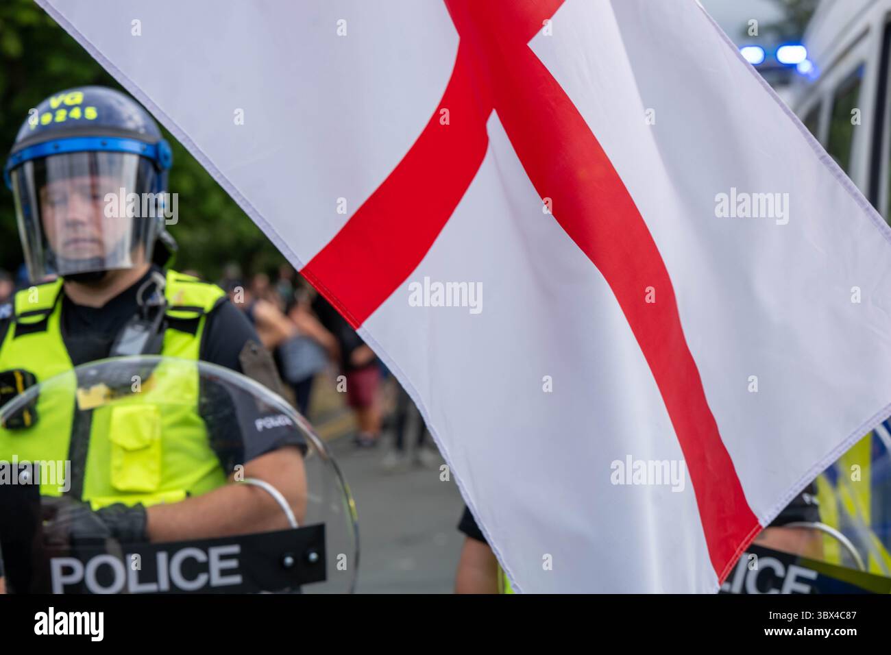 Epping Essex 17 Jul 2025 A small group of pro immigrant protesters were trapped in the middle of Epping by locals and anti immigrant protesters. The pro immigrant protesters were protected by Essex Police, some in riot gear with shields. St George’s flag Credit: Ian Davidson/Alamy Live News Stock Photo