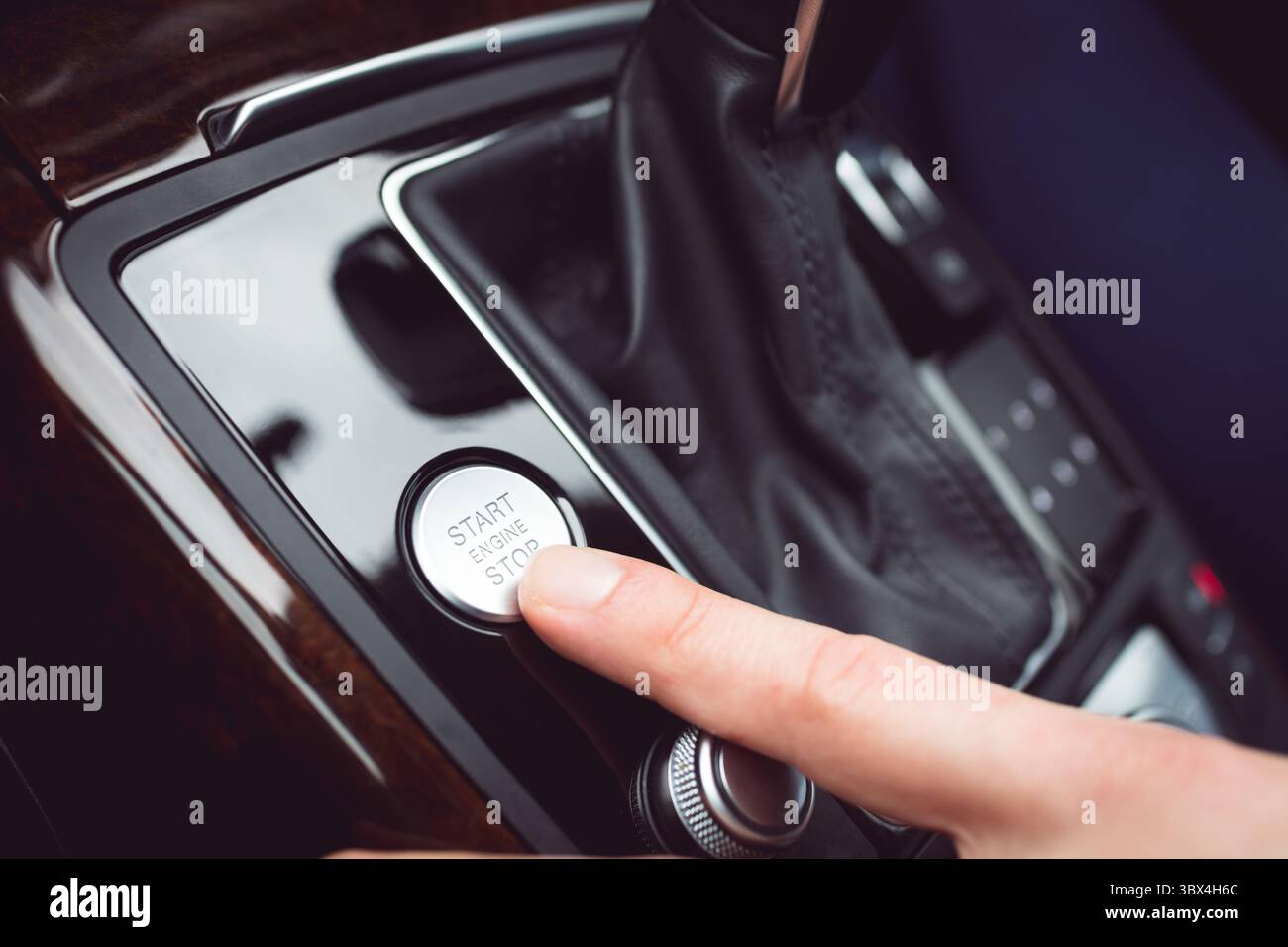 Man pressing start button in car Stock Photo