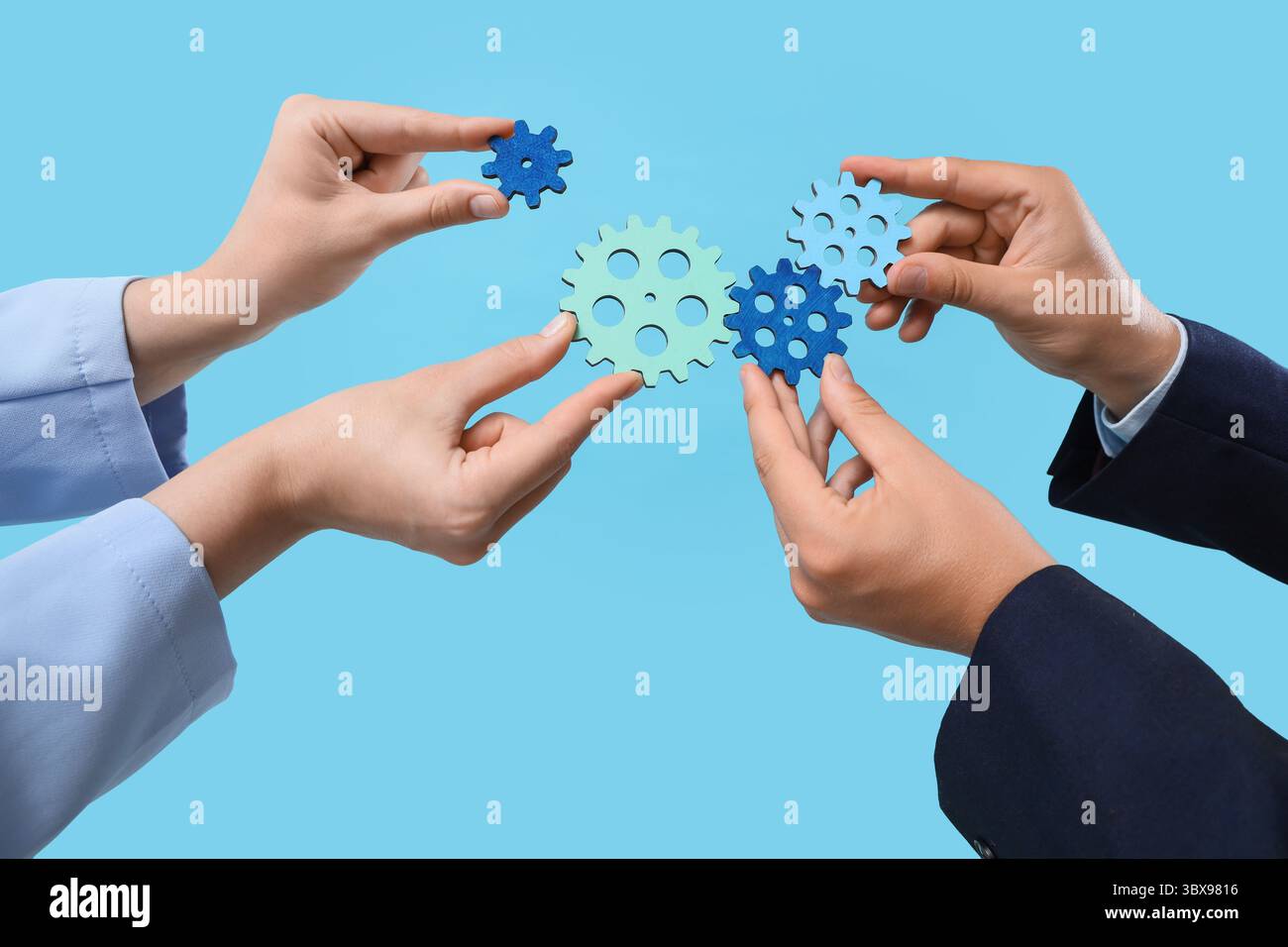 Hands with gears on blue background Stock Photo