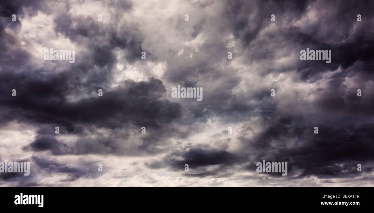 Dense dark grey clouds are being shown in open sky flat design, featuring layered storm patterns Stock Photo