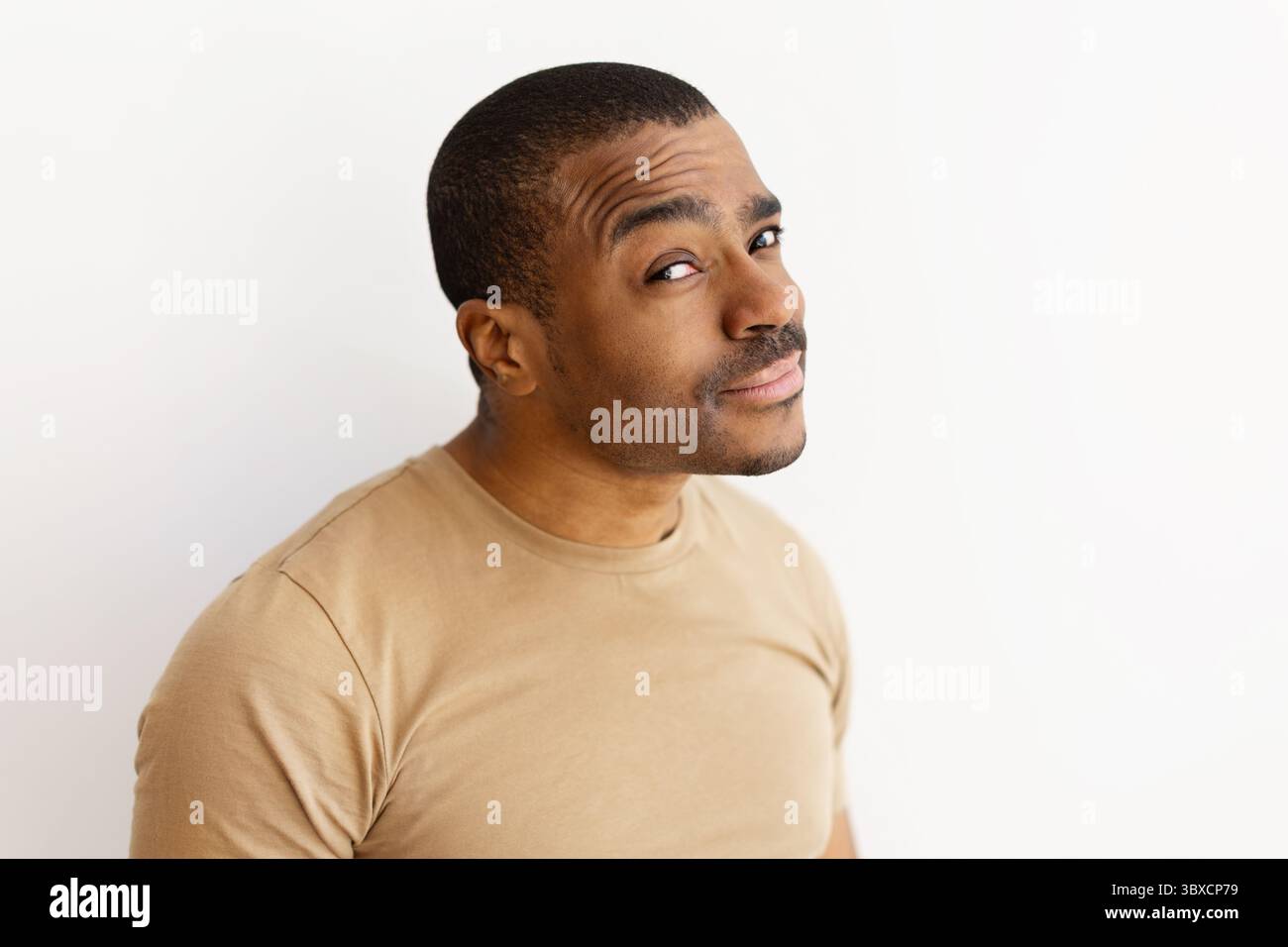 Black man raising eyebrow with skeptical or doubtful expression Stock Photo
