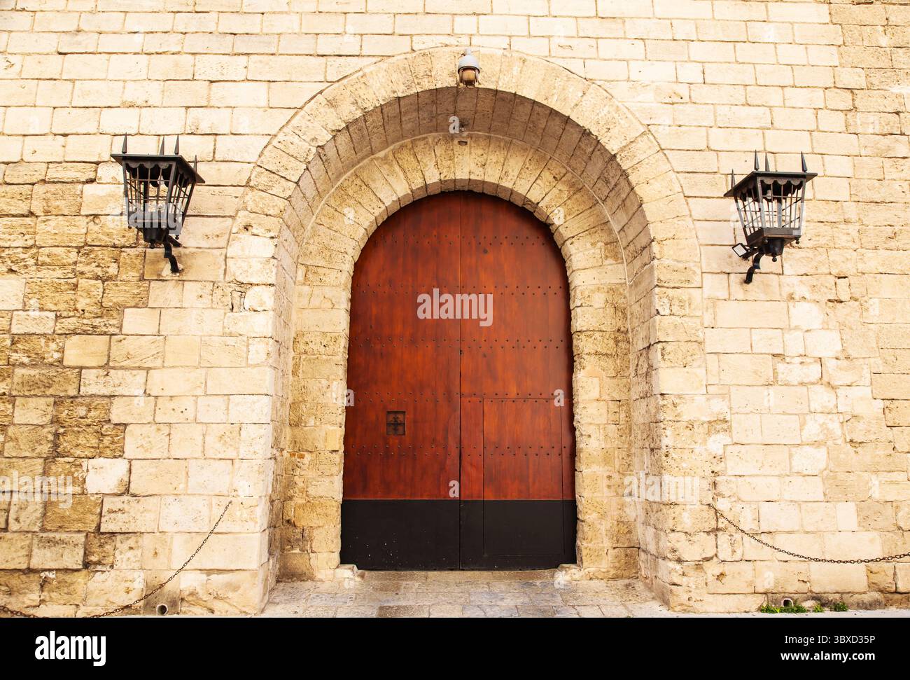Wall with a door and lamps on the wall of a medieval castle Stock Photo ...