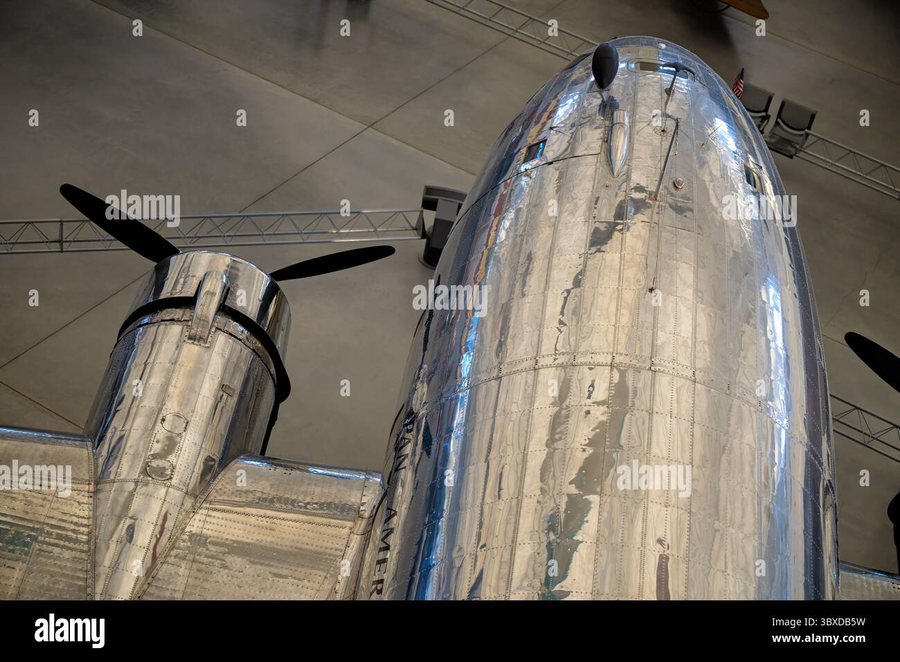 CHANTILLY, Virginia — The Boeing 307 Stratoliner Clipper Flying Cloud, the world's first pressurized airliner, is displayed at the Smithsonian's Steven F. Udvar-Hazy Center. First flown in 1938, the Stratoliner could carry 33 passengers at 6,096 meters (20,000 feet) while maintaining cabin pressure equivalent to 2,438 meters (8,000 feet), allowing flights above most weather systems. The aircraft incorporated wings, tail, and engines from the Boeing B-17C bomber with a wide fuselage fitted with sleeper berths and reclining seats. Pan American Airways operated this particular aircraft as part of Stock Photo