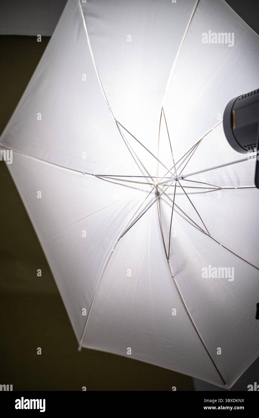 Studio lighting, white umbrella on black background. Light source in photo studio Stock Photo