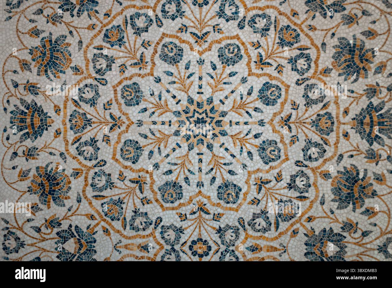 Intricate mosaic featuring floral patterns in blue and gold marble inlay flooring Stock Photo