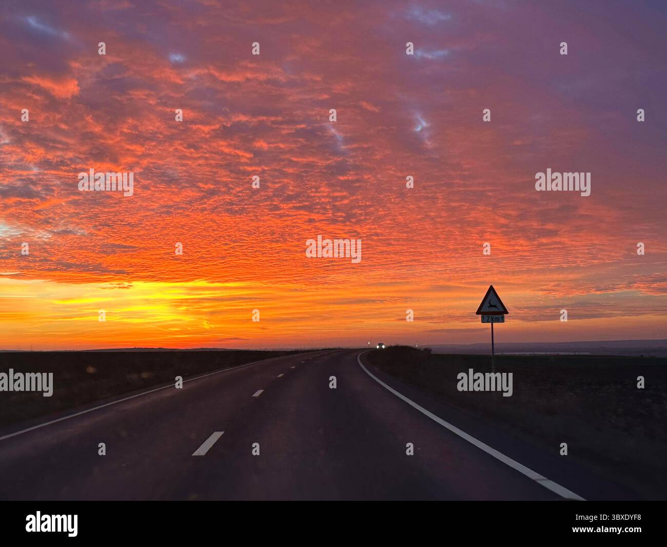 Highway journey with a vibrant sky and picturesque sunset in the backdrop - Smartphone Captured Stock Image