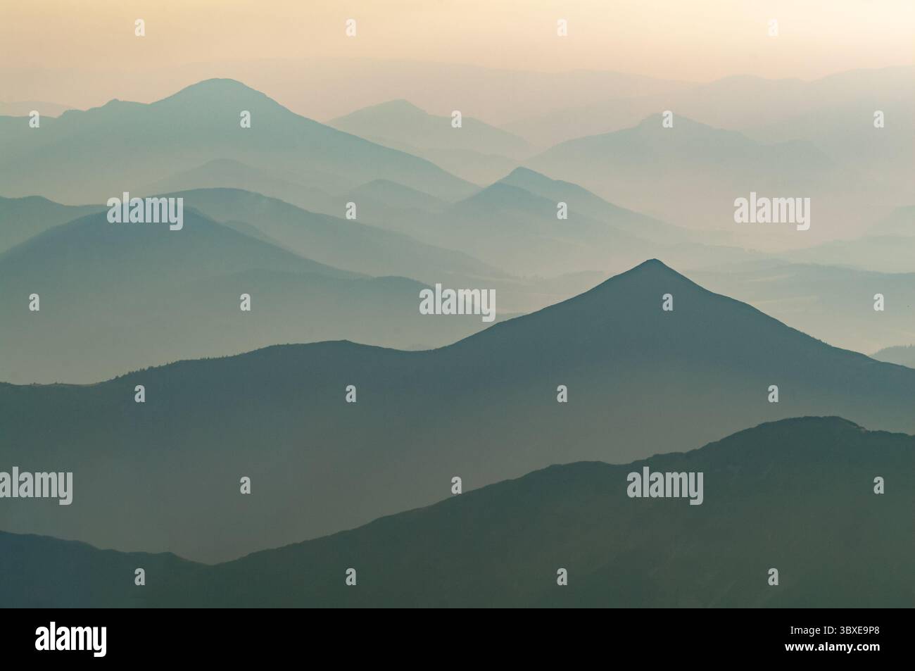 Aerial view of the misty mountain ranges stretching into the pale ...