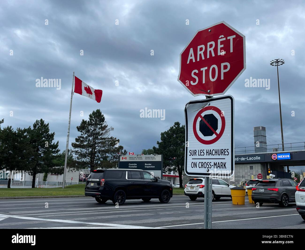 A bilingual stop sign, in French and English, advises cars driving to ...