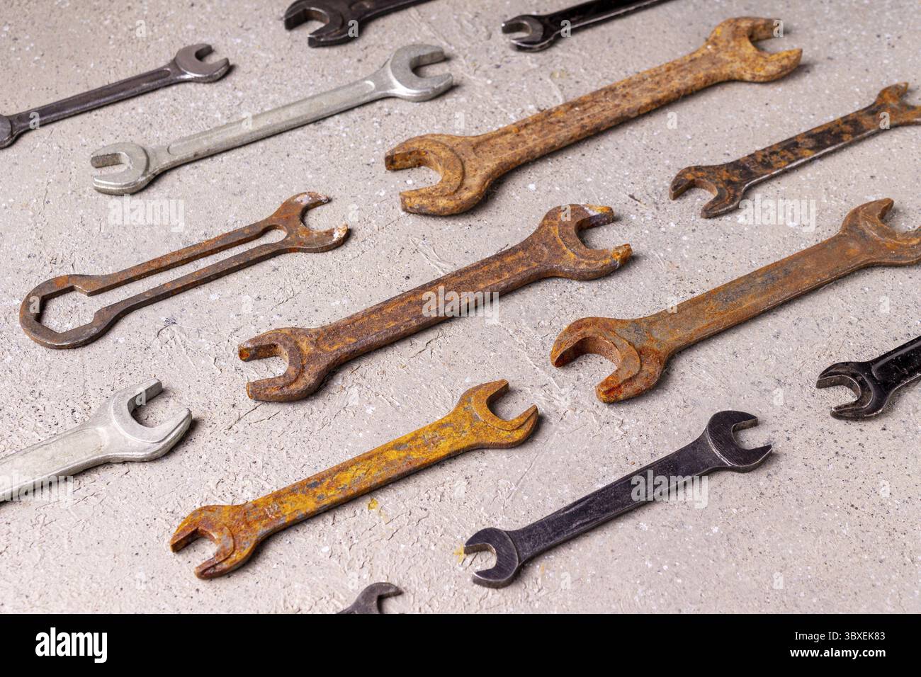 Old rusty tools lie on gray plaster, pattern Stock Photo