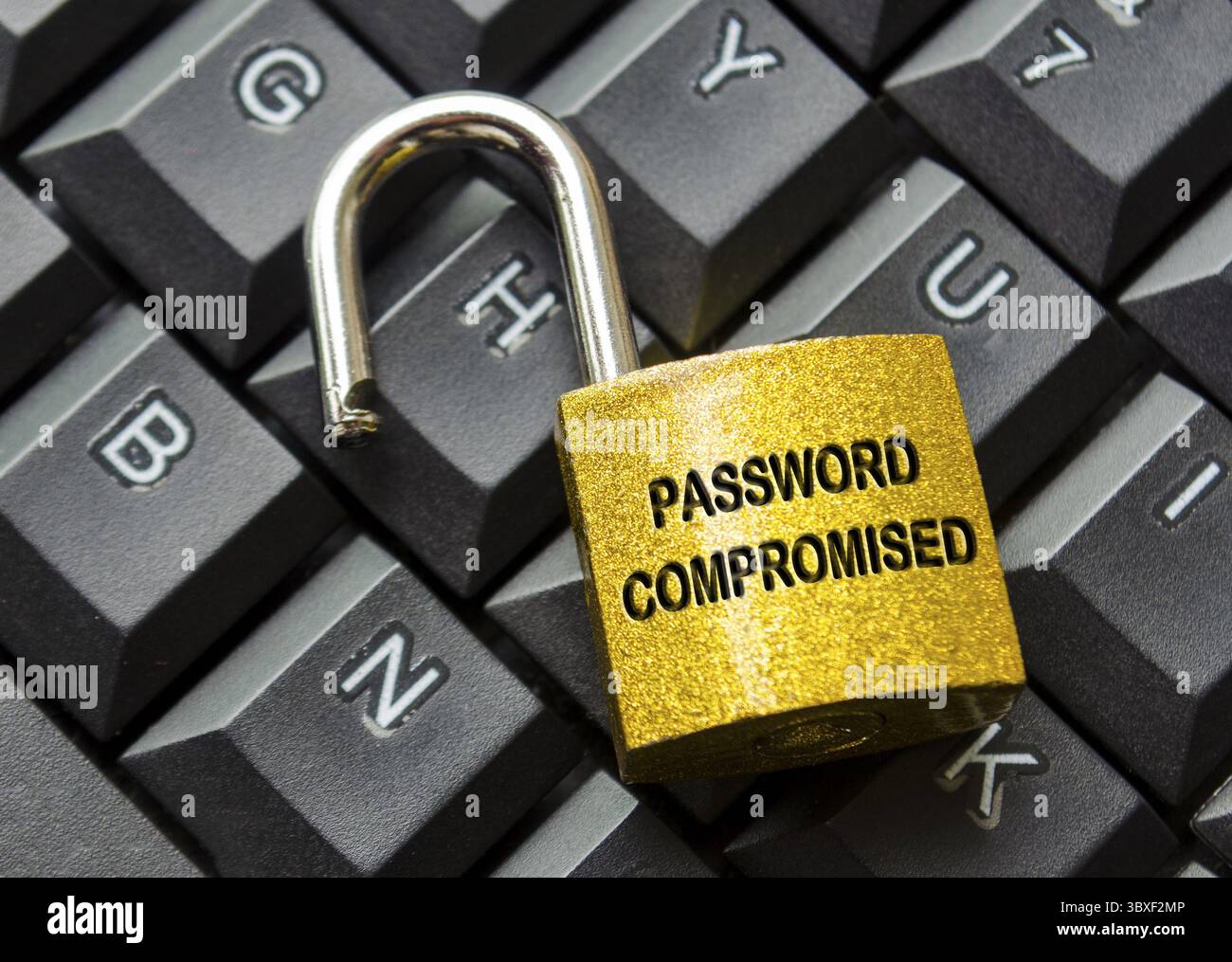 Top view of Password Compromised text engraved on padlock with keyboard background. Password and cybersecurity concept Stock Photo