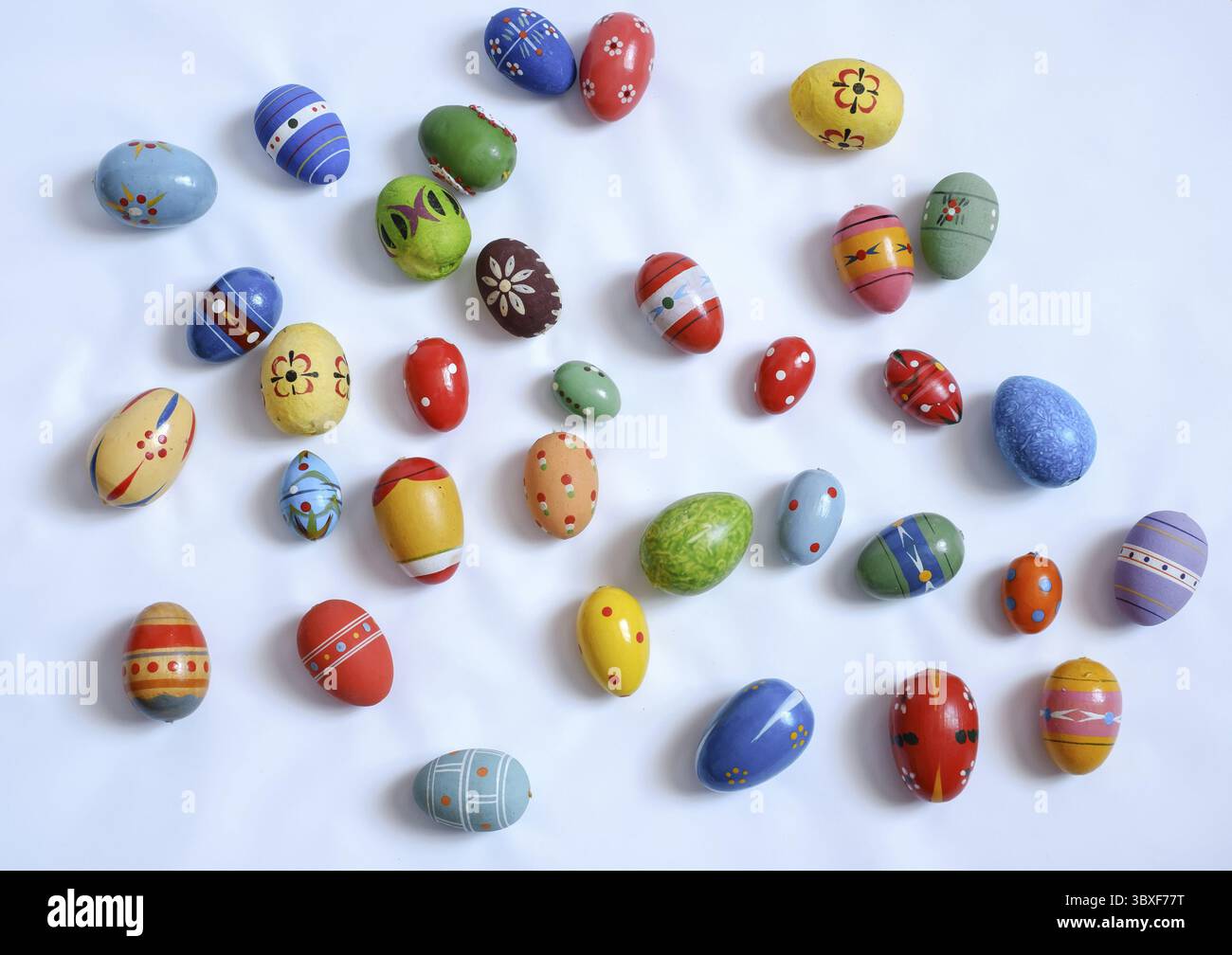 Multicolored wooden eggs on white background Stock Photo