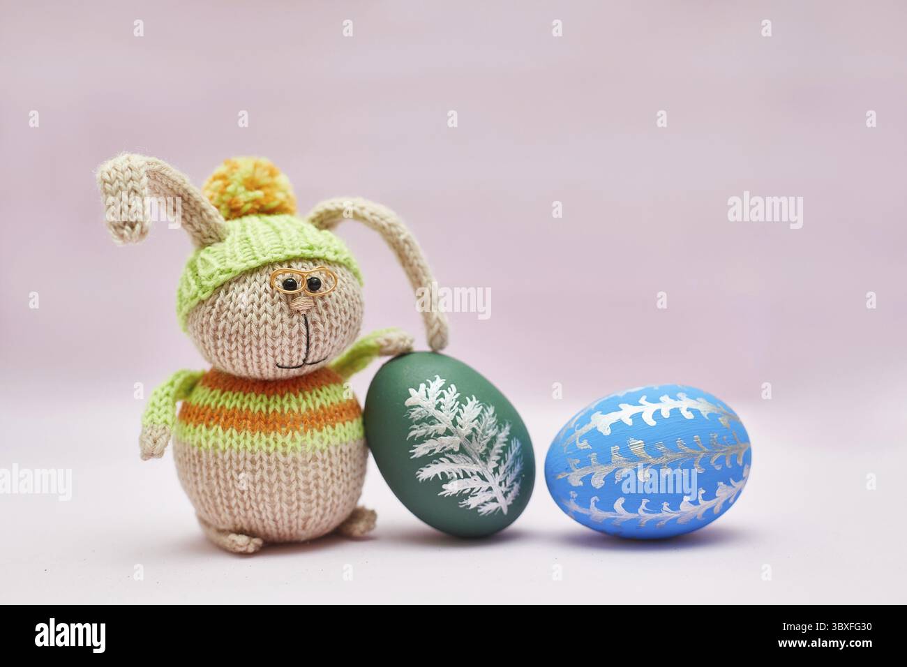 Knitted rabbit and two Easter eggs for a postcard Stock Photo