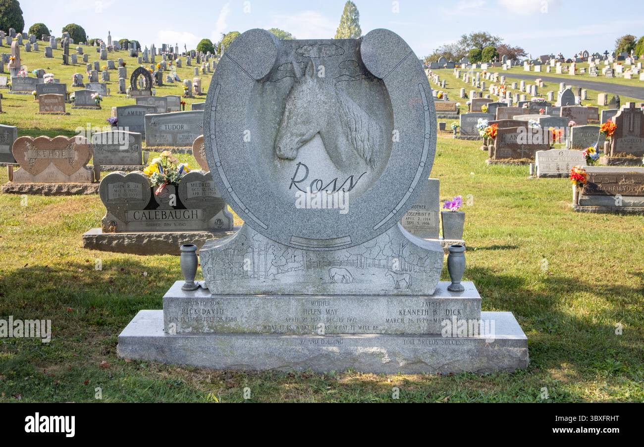 A unique horseshoe-shaped gravestone stands out in a Baltimore cemetery, symbolizing luck, strength, and perhaps a nod to a love of horses. Stock Photo