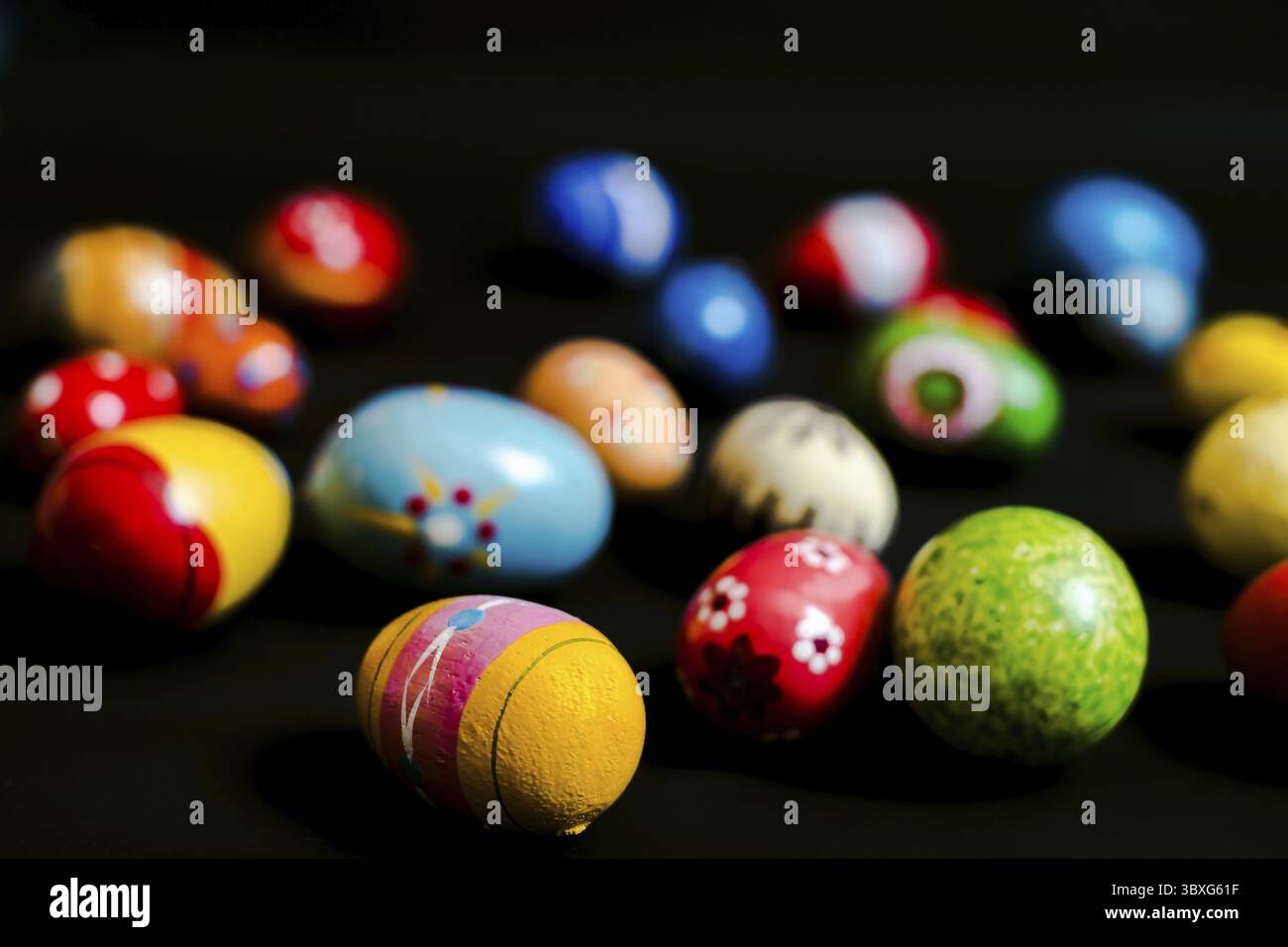 Multicolored wooden eggs on black background Stock Photo