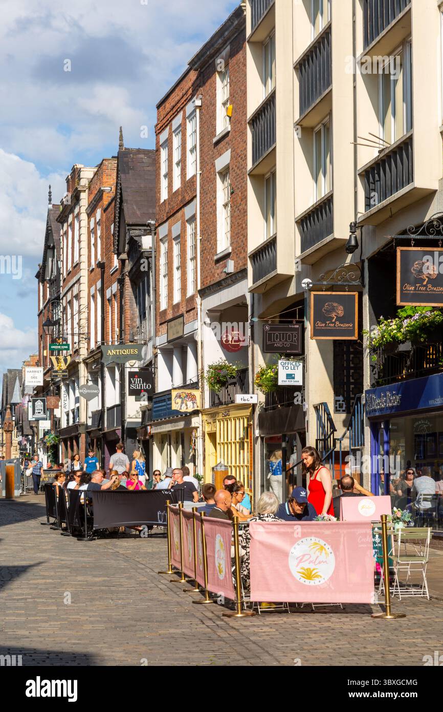 People dining and drinking seated on the street, Bridge Street Chester, Cheshire, UK. 2025 Stock Photo