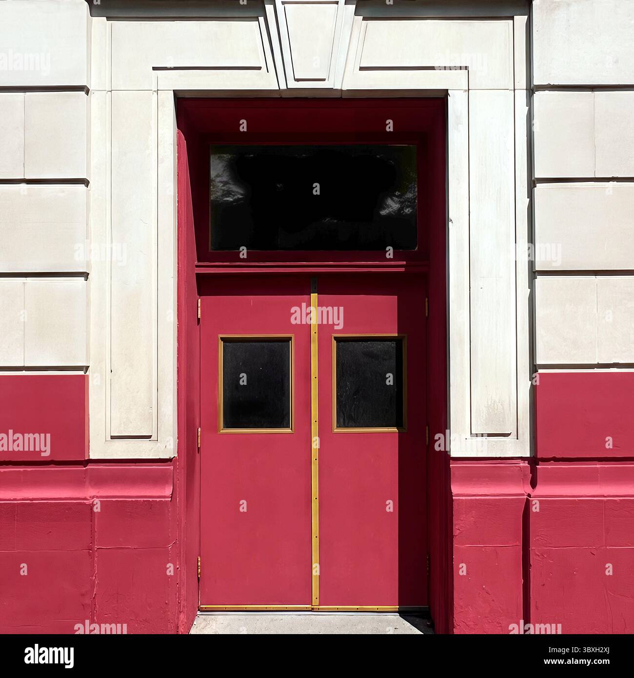 Symmetrical double red doors with brass trim and transom window set in a geometric stone facade of a historic Chicago building, midday light. - Smartphone Captured Stock Image