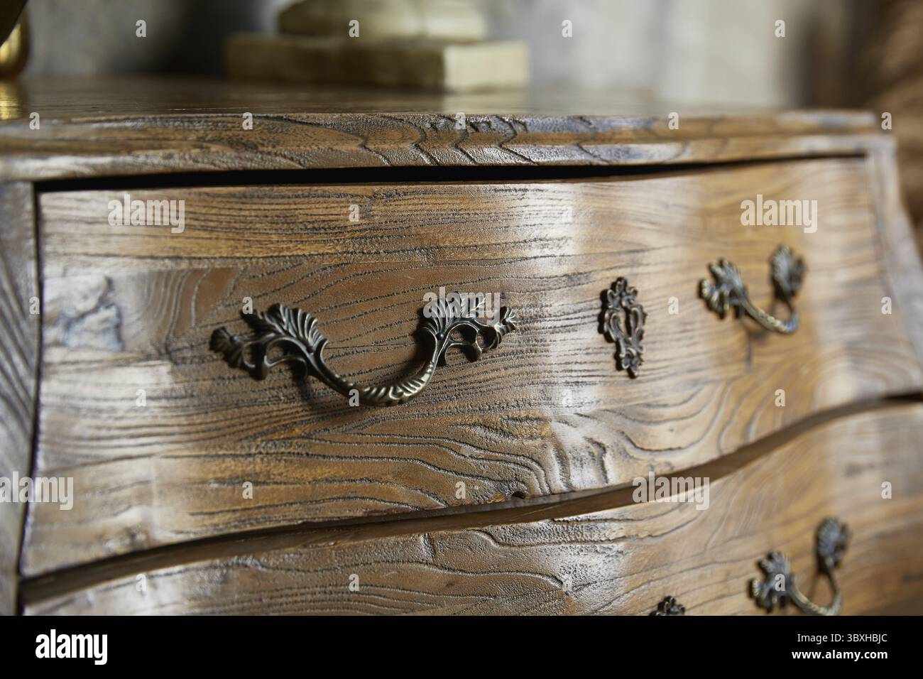 Vintage curved chest of drawers close-up. Forged handles Stock Photo