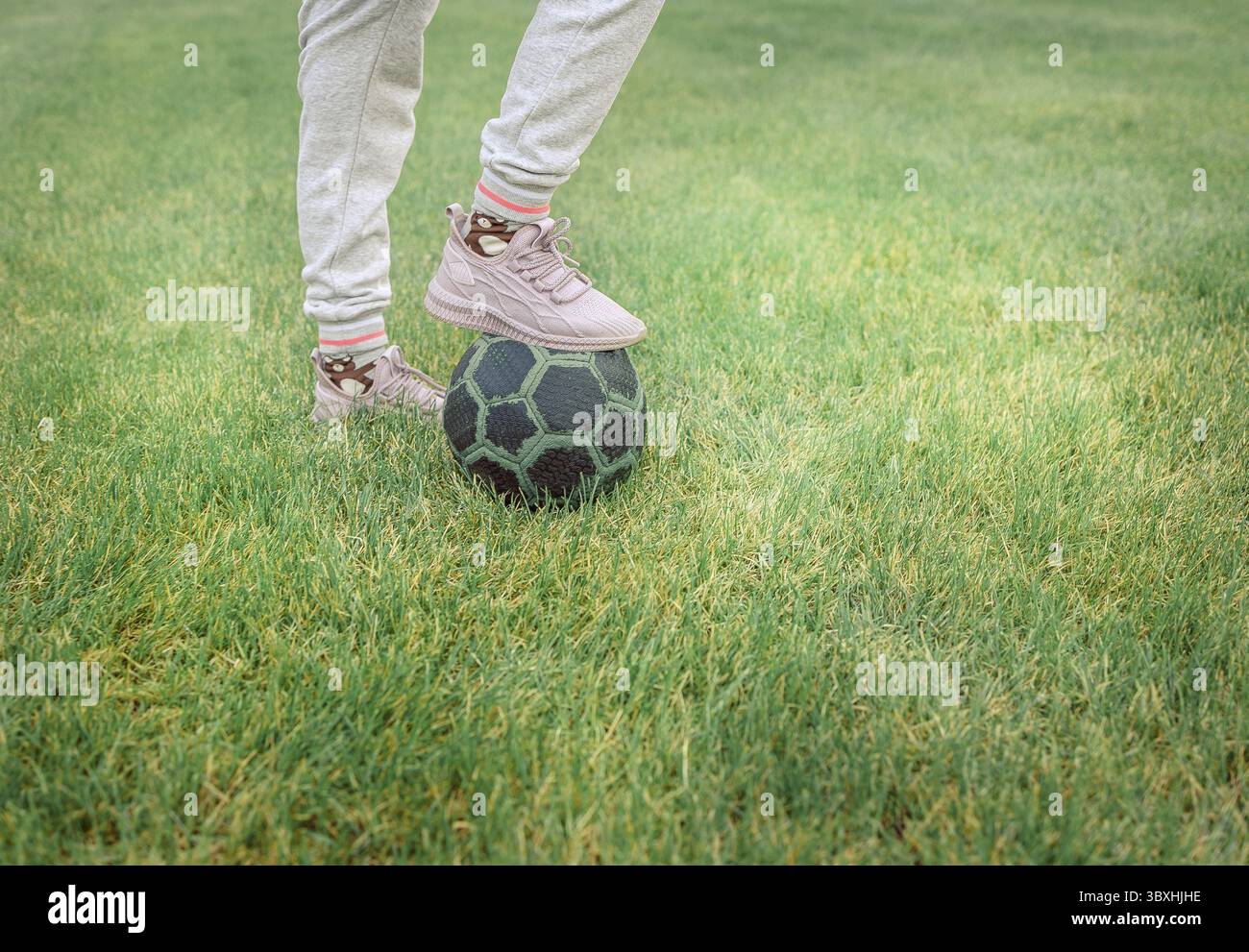 Cute little girl playing football with soccer ball on green lawn in ...
