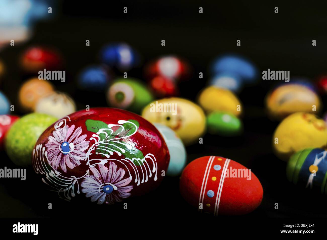 Multicolored wooden eggs on black background Stock Photo