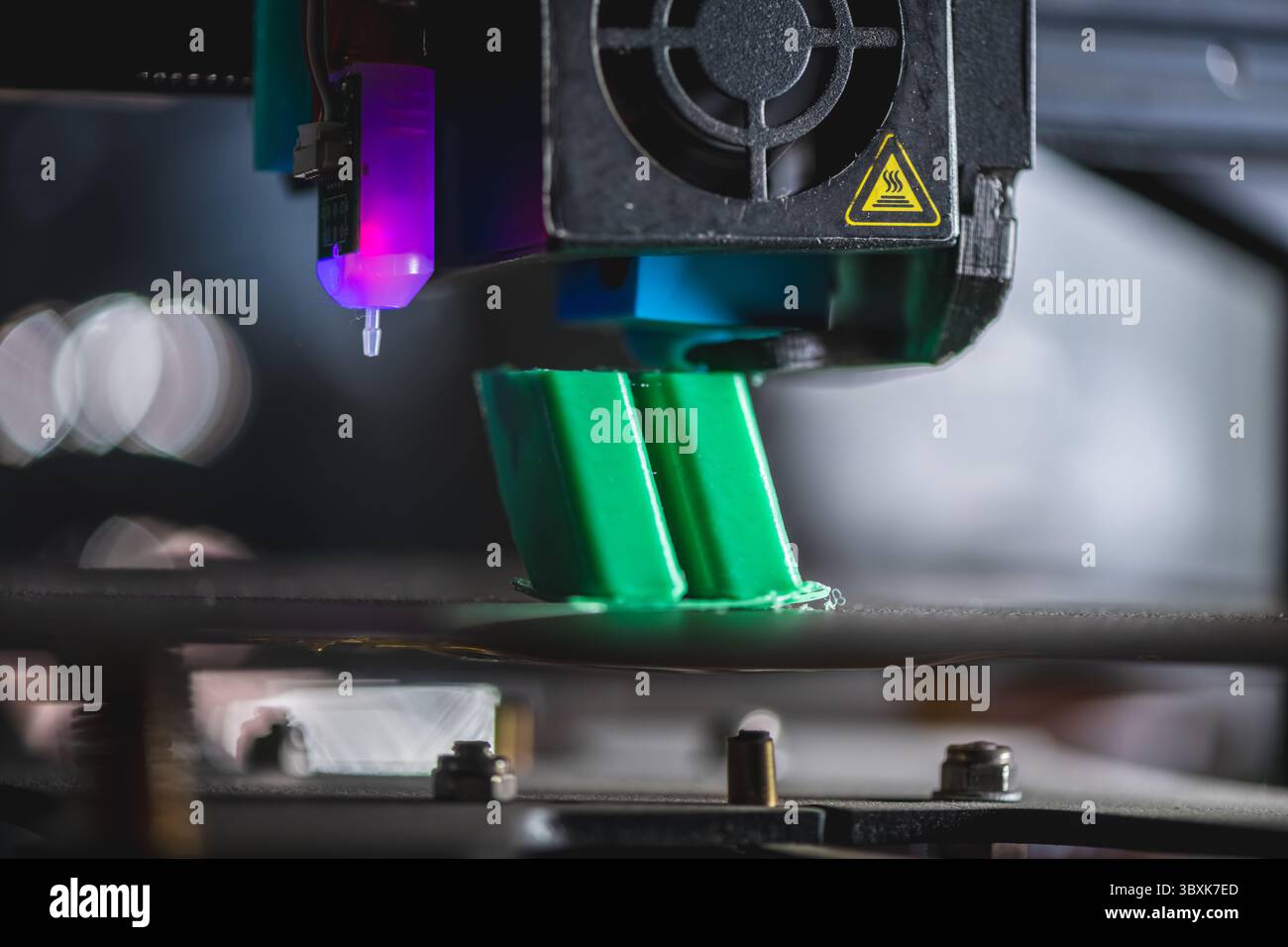 Modern 3d printer creating a green plastic object using innovative technology in a laboratory setting, showcasing the advancements in additive manufac Stock Photo