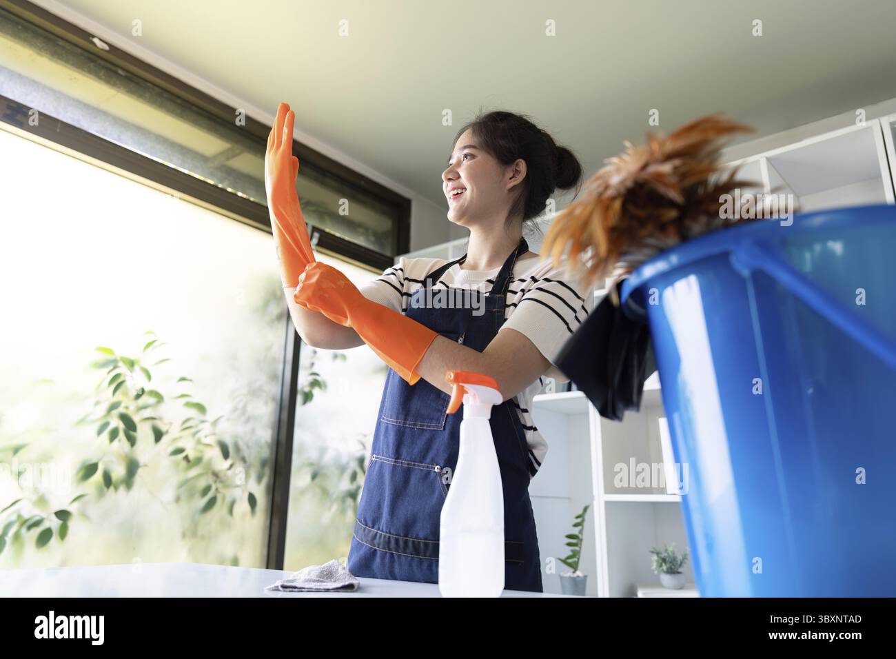An energetic janitorial professional prepares for office cleaning tasks with enthusiasm, demonstrating readiness and focus on maintaining a profession Stock Photo