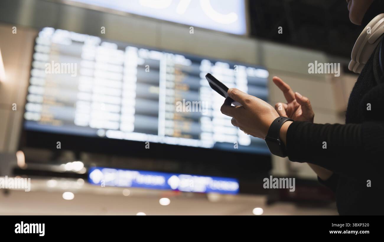 Woman in international airport, using mobile smartphone and checking ...
