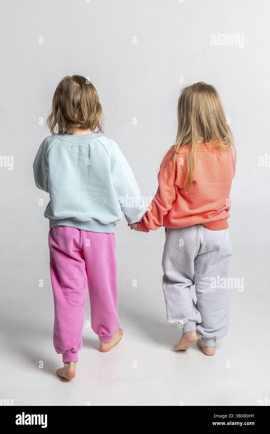Colorful children's sweatshirts and trousers close-up. Vertical photo. Stock Photo